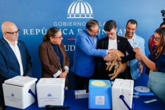 Participantes junto a un gato y materiales de vacunación veterinaria, ante un fondo de Salud Pública.