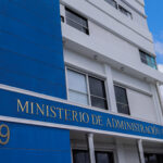 Fachada azul y blanca con el letrero del Ministerio de Administración Pública.