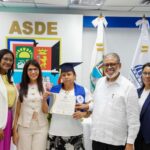 Participantes muestran un certificado de formación durante un acto institucional.