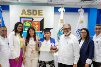 Participantes muestran un certificado de formación durante un acto institucional.