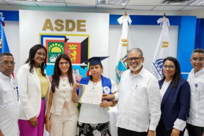 Participantes muestran un certificado de formación durante un acto institucional.