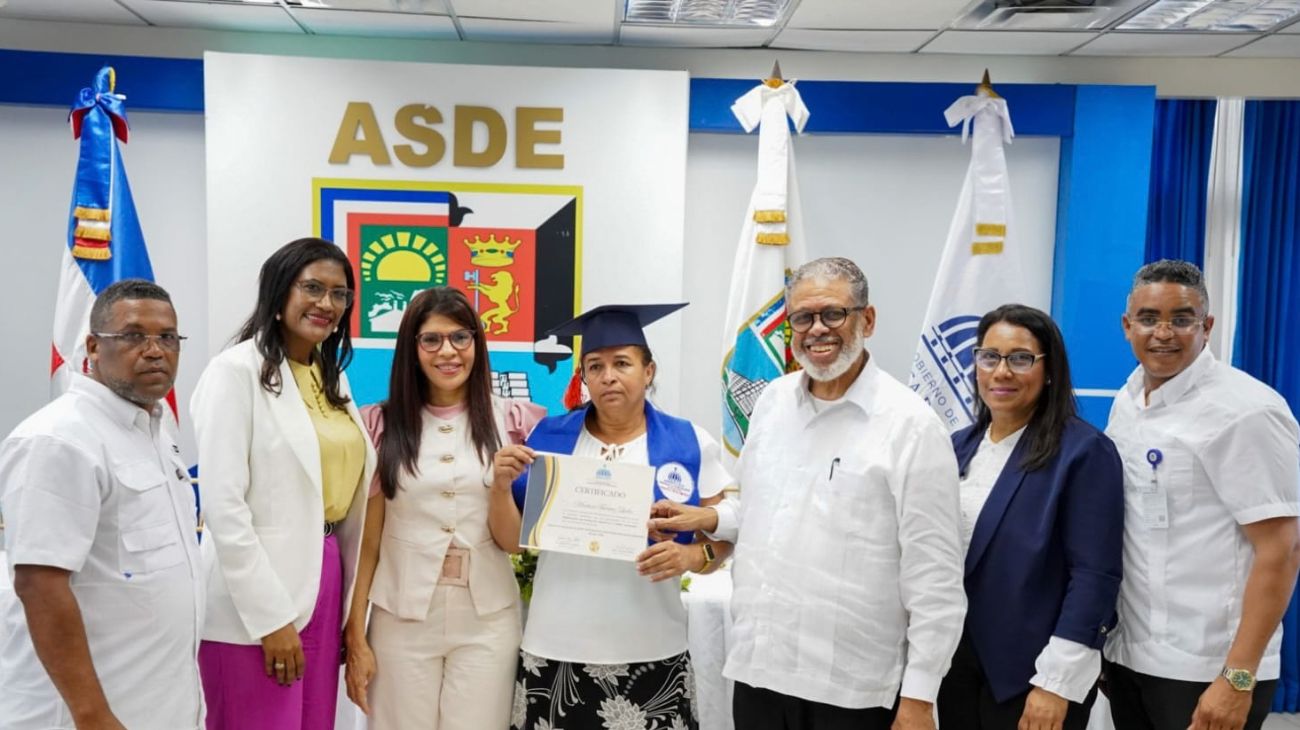 Participantes muestran un certificado de formación durante un acto institucional.