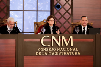 Tres participantes en una mesa institucional con el rótulo del Consejo Nacional de la Magistratura.