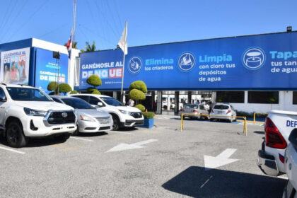 Edificio y estacionamiento con una campaña pública contra el dengue.