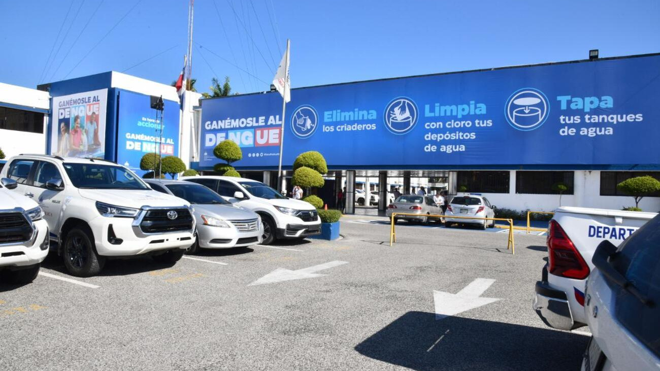 Edificio y estacionamiento con una campaña pública contra el dengue.
