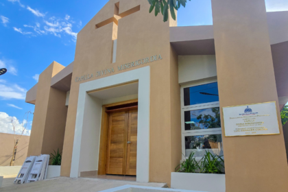 Fachada de una capilla con cruz, rótulo Divina Misericordia y placa institucional.