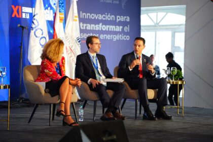 Tres panelistas sentados con micrófonos ante una gráfica de la XI Semana de la Energía.