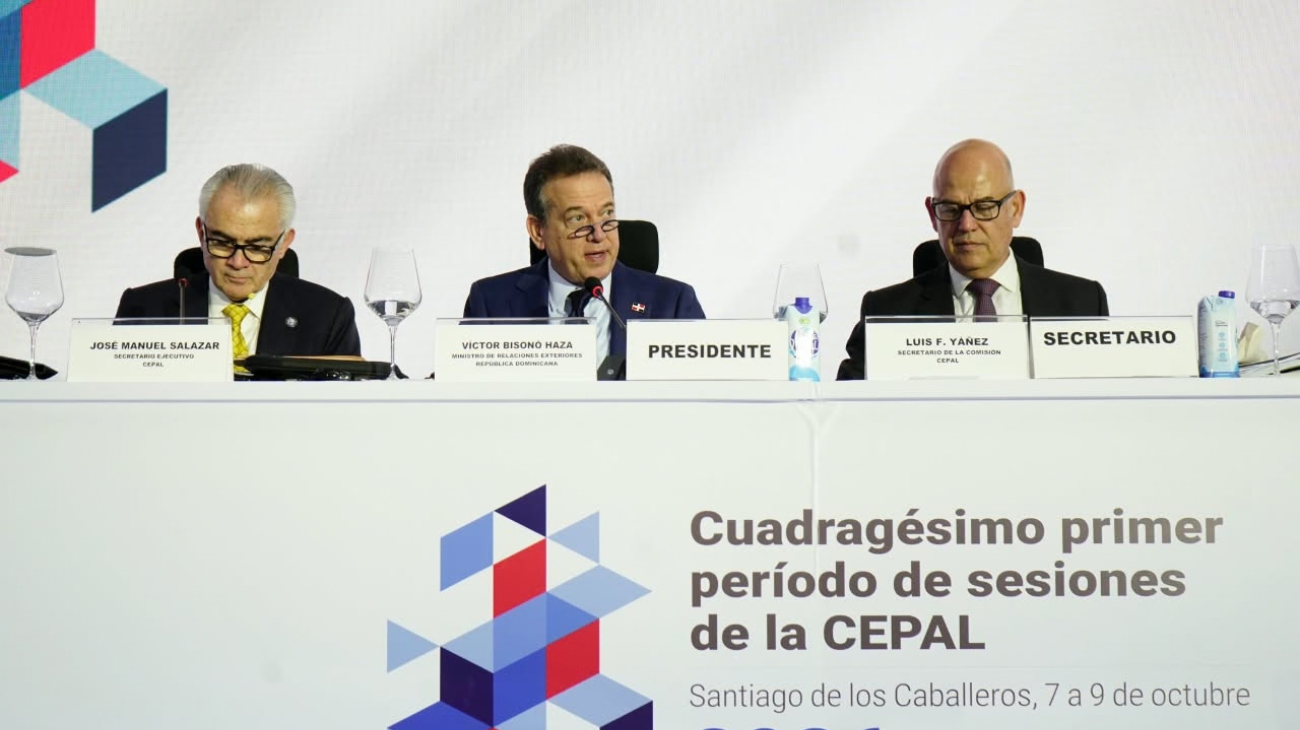 Tres panelistas ante señalética de la Cepal y placas de cargos públicos.