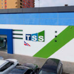 Fachada de la TSS con estacionamiento y vehículos.