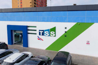 Fachada de la TSS con estacionamiento y vehículos.