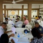 Participantes sentados en mesas durante una jornada comunitaria en el Club Rotario.