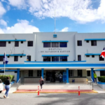 Entrada del Hospital Salvador B. Gautier, con banderas, vehículos y transeúntes.