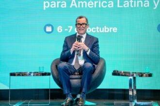 Panelista con micrófono y acreditación de un evento institucional.