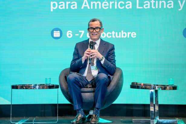 Panelista con micrófono y acreditación de un evento institucional.