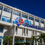 Fachada de un edificio con el logotipo ProDominicana, ventanas y palmeras en primer plano.