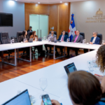 Participantes alrededor de mesas en forma de U, con el rótulo Hacienda y Economía al fondo.