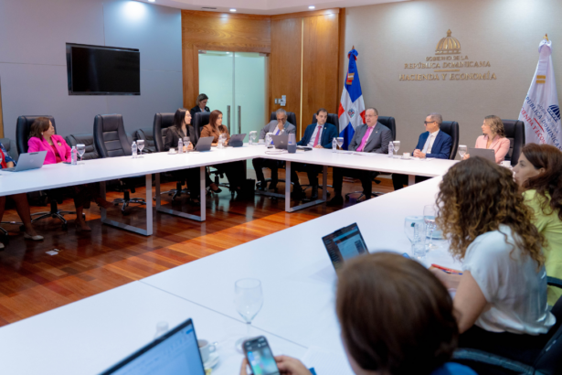 Participantes alrededor de mesas en forma de U, con el rótulo Hacienda y Economía al fondo.