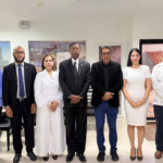 Grupo en un salón entre banderas dominicana y venezolana.