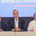 Participantes en una mesa de anuncio público con micrófono.