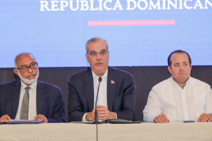 Participantes en una mesa de anuncio público con micrófono.
