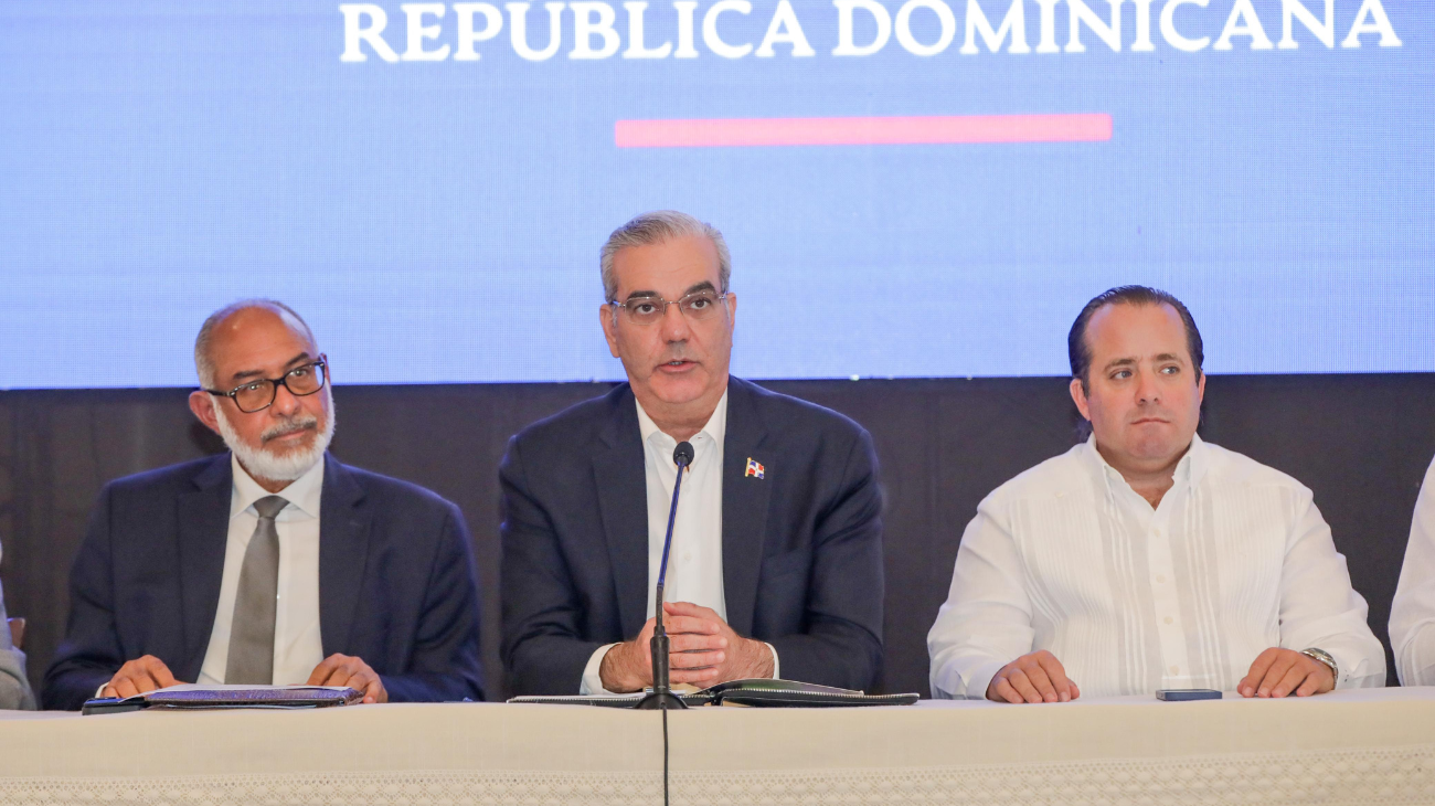 Participantes en una mesa de anuncio público con micrófono.