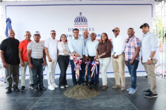 Participantes con palas ante un montículo de tierra y un fondo del Ministerio de Deportes.
