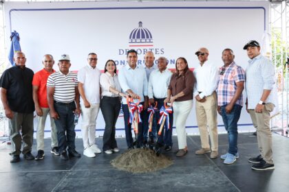 Participantes con palas ante un montículo de tierra y un fondo del Ministerio de Deportes.