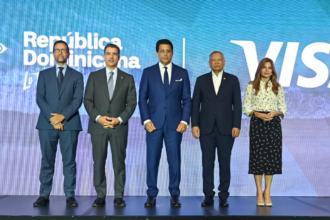 Cinco personas posan en un escenario ante las marcas República Dominicana y Visa.