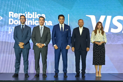 Cinco personas posan en un escenario ante las marcas República Dominicana y Visa.