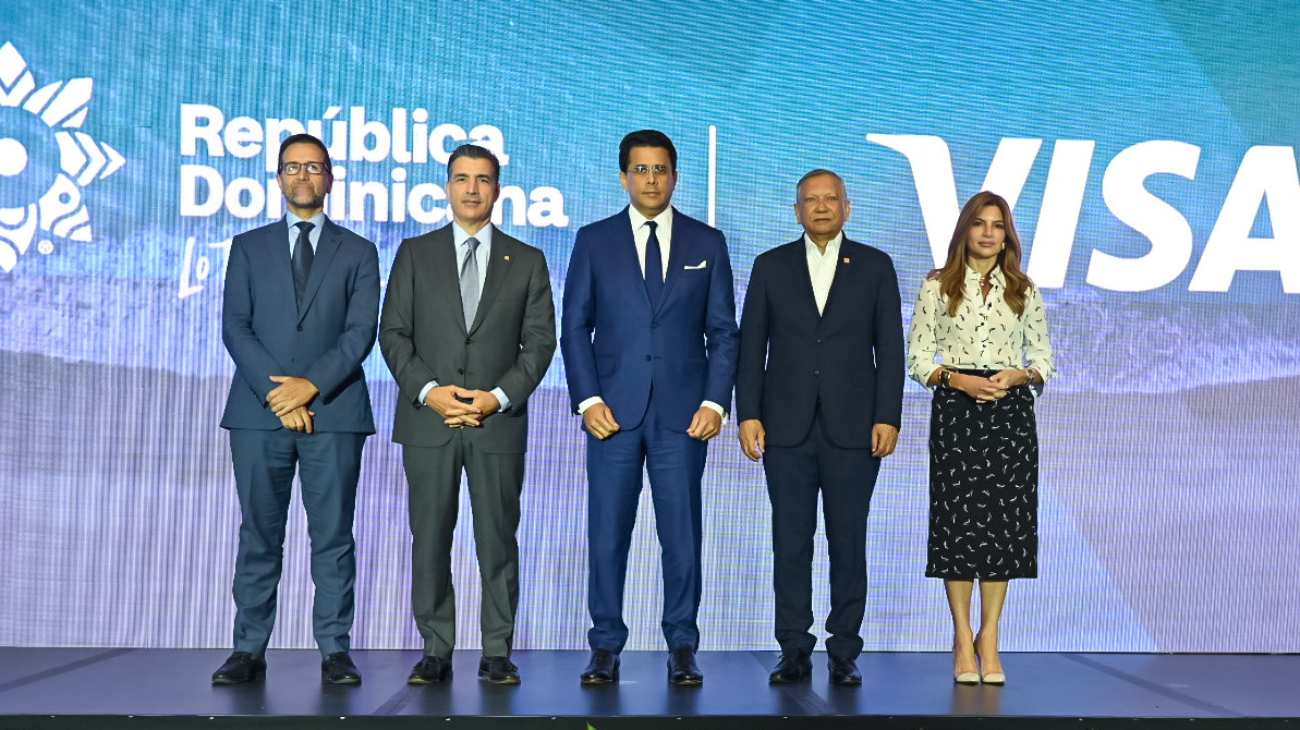 Cinco personas posan en un escenario ante las marcas República Dominicana y Visa.
