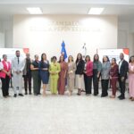 Grupo en un salón institucional, con pantallas sobre comunicación e igualdad.
