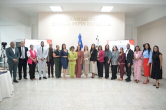 Grupo en un salón institucional, con pantallas sobre comunicación e igualdad.
