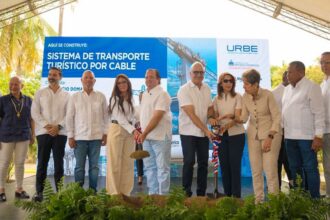 Participantes con palas ante un cartel de transporte turístico por cable.