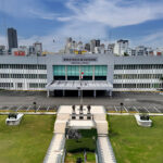 Edificio con el rótulo Ministerio de Defensa, jardines y monumentos en el frente.