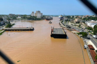 Vista elevada del puente flotante, el río y las vías urbanas próximas.