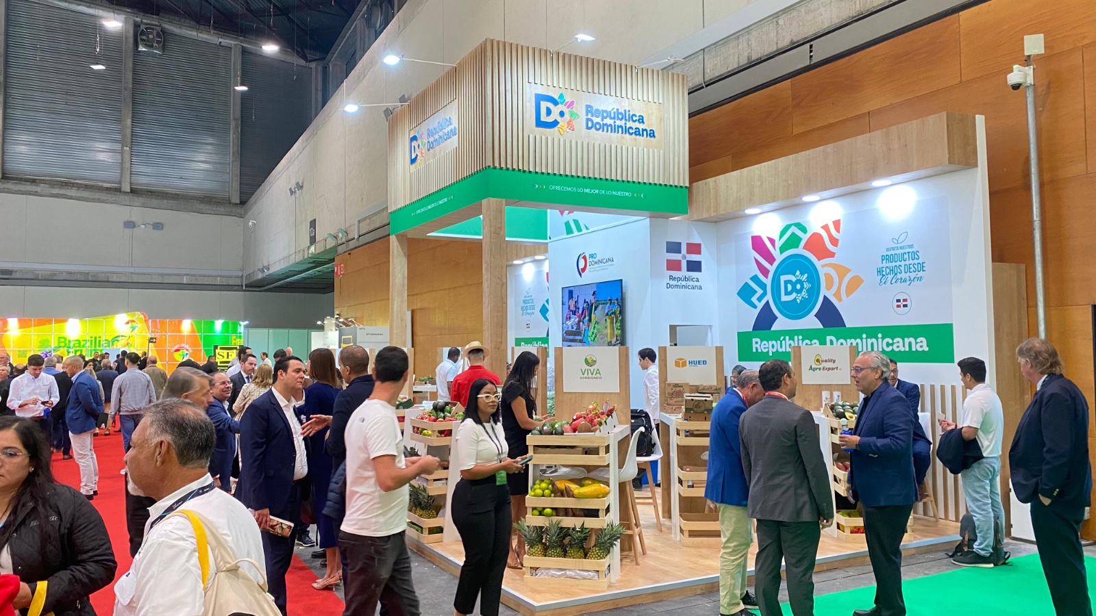 Stand de República Dominicana con productos y visitantes de feria.
