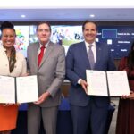 Cuatro participantes muestran acuerdos institucionales durante un acto público de la OPS.