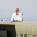 Participantes en una mesa institucional con micrófonos.