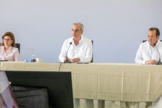 Participantes en una mesa institucional con micrófonos.