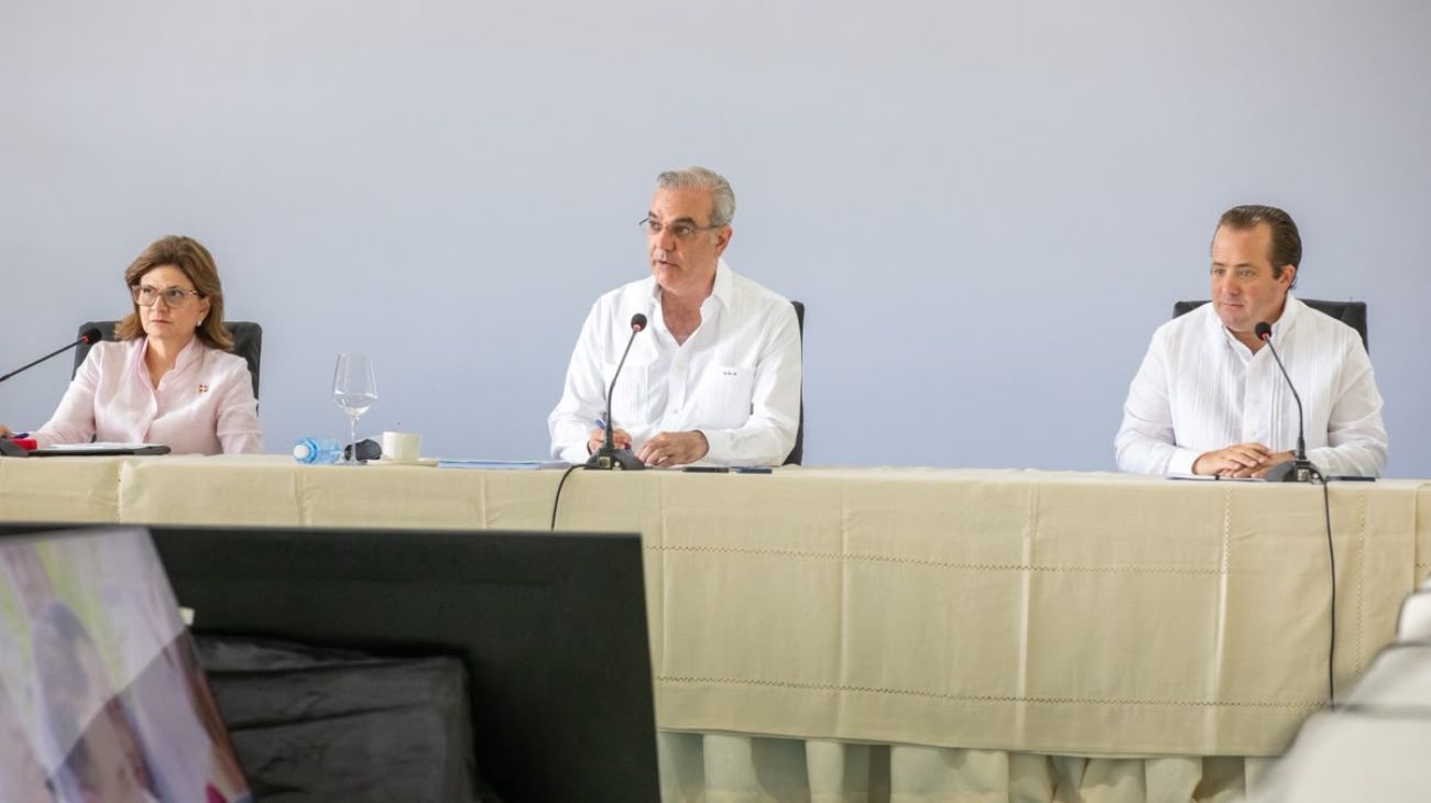 Participantes en una mesa institucional con micrófonos.