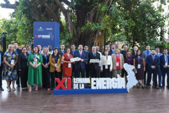 Grupo de participantes al aire libre junto a un letrero de la XI Semana de la Energía.