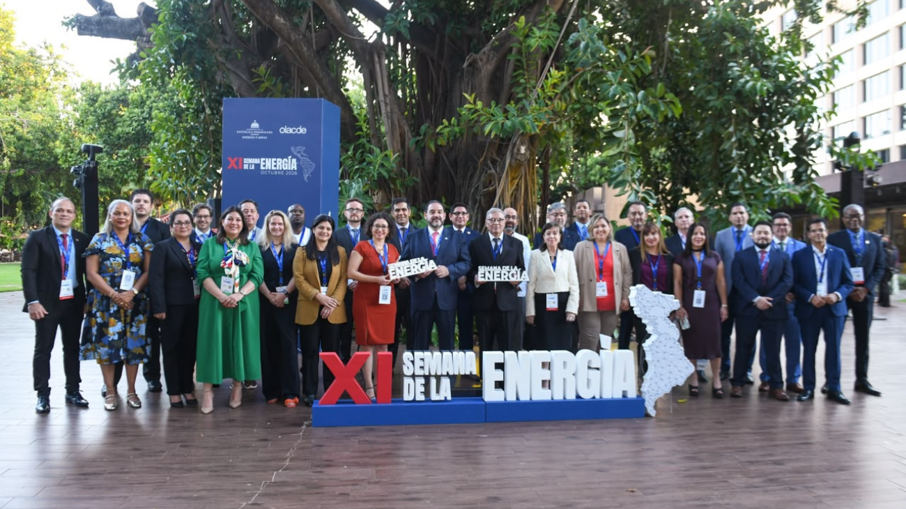 Grupo de participantes al aire libre junto a un letrero de la XI Semana de la Energía.