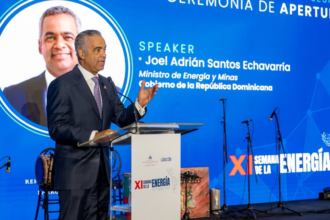 Ponente en un atril ante una pantalla de la ceremonia de apertura de la XI Semana de la Energía.