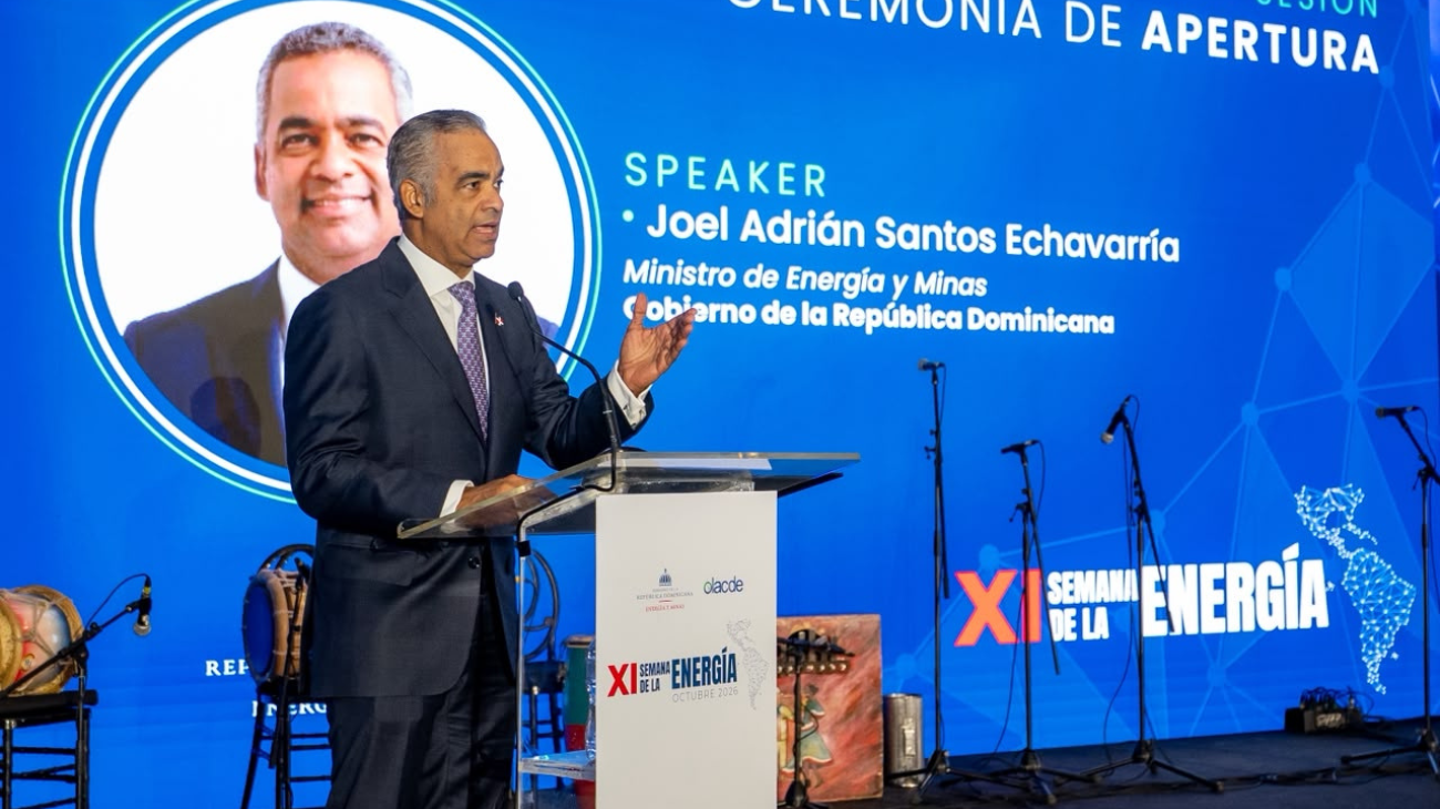 Ponente en un atril ante una pantalla de la ceremonia de apertura de la XI Semana de la Energía.
